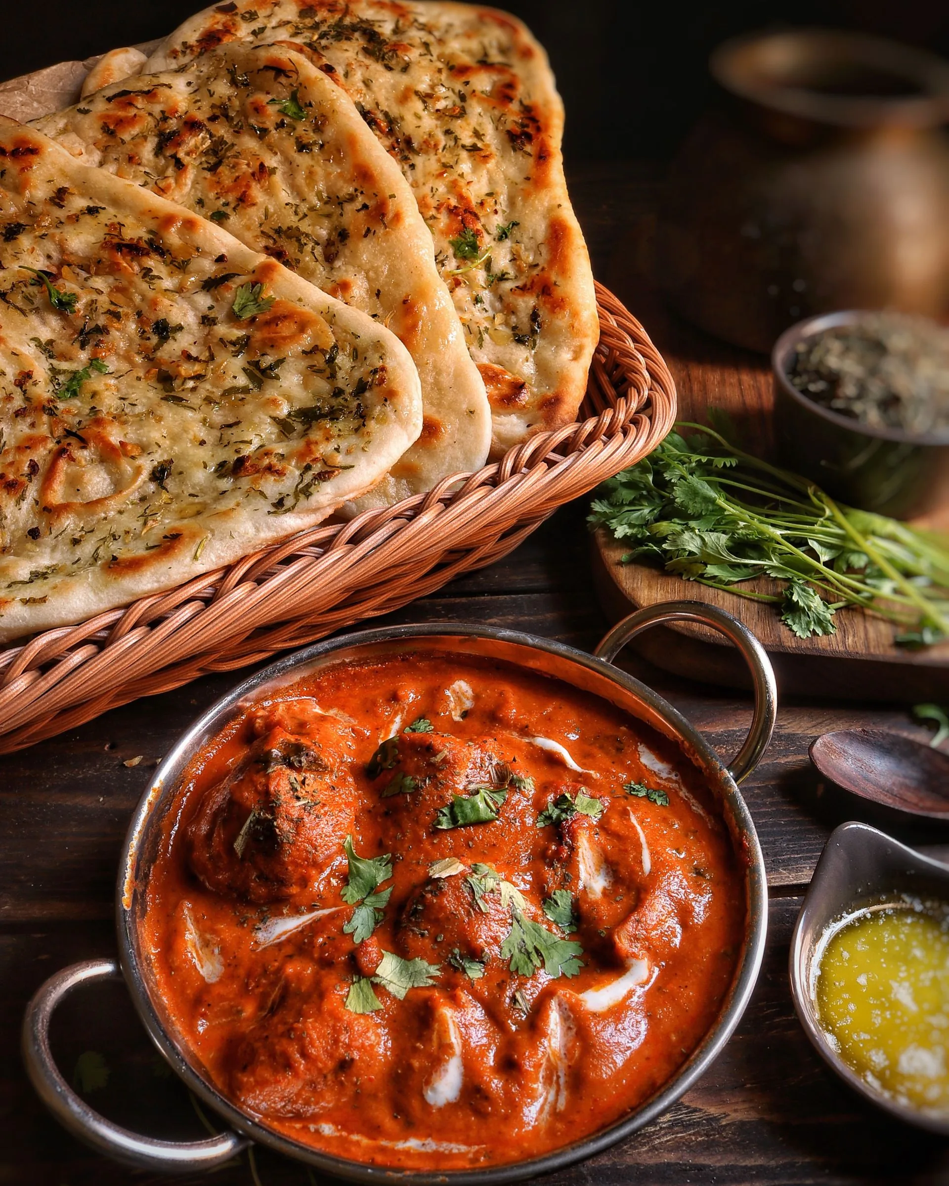 Butter chicken in a steel kadhai with garlic naan and ghee (illustrative photo)