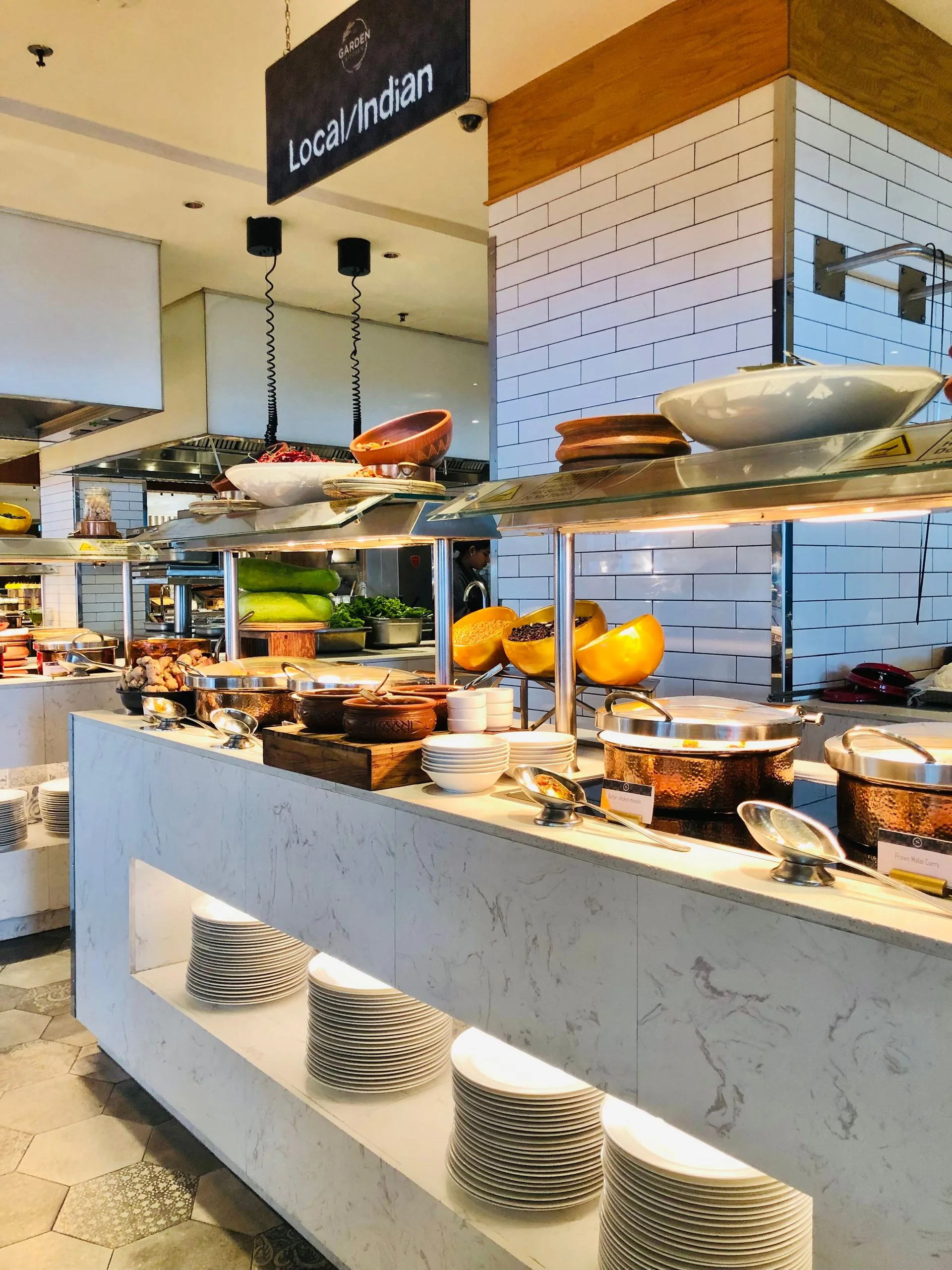 Long Indian buffet counter with copper handis and serving dishes at a premium catering setup (illustrative photo)