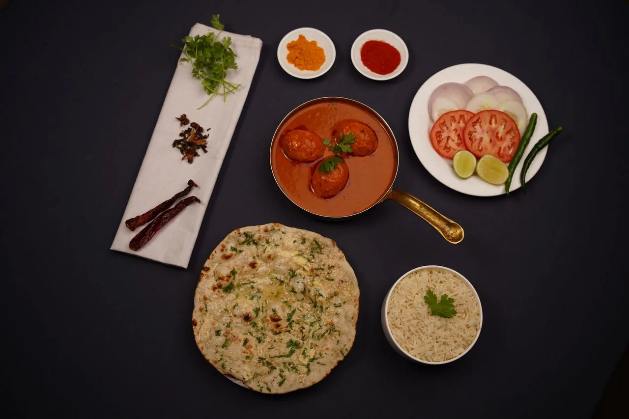 Premium plated North Indian meal with kofta curry, naan and rice (illustrative photo)